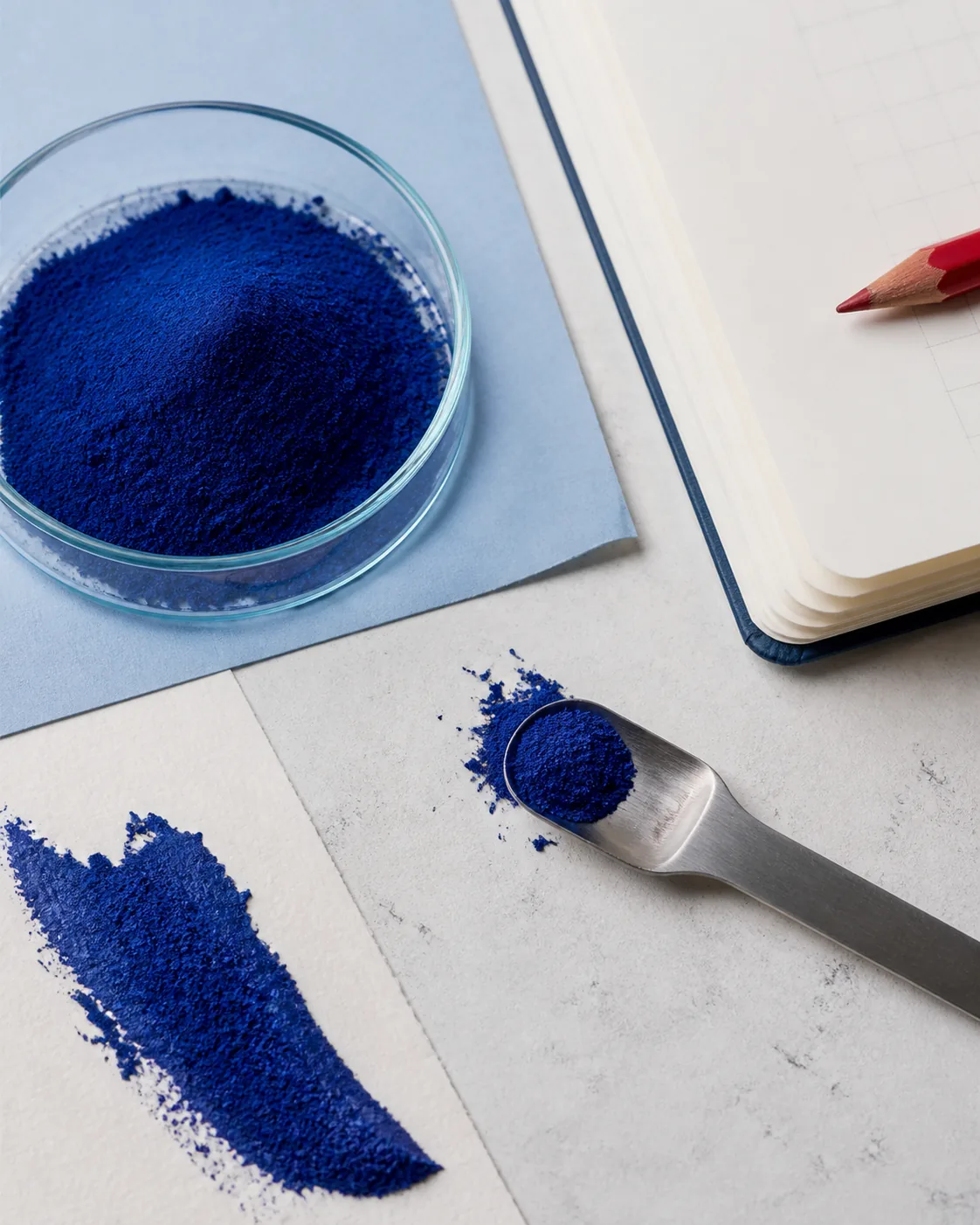 Blue spirulina powder beside a research notebook