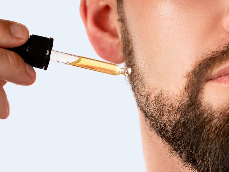 man applying beard growth oil, exploring the benefits and efficacy of beard growth oil